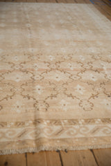 Vintage distressed Oushak carpet detail: beige trellis pattern, floral blossoms, abrashes.