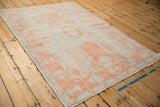 Distressed vintage Oushak rug with even wear, highlighting a cantaloupe geometric border.