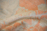 Distressed Oushak rug pile with even wear, showing ivory, cantaloupe, pale blue tones.