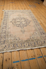Distressed vintage Sparta rug, right border with dusty slate blue motifs and beige pile showing foundation.