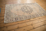 Distressed vintage Sparta rug, fringed end and worn slate blue border detail.