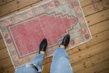 Stepped prayer spandrel and faded floral border on a distressed Oushak rug.