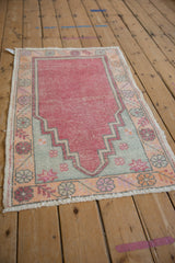 Decorative distressed vintage Oushak rug with dusty cherry red prayer motif and pale blue details.