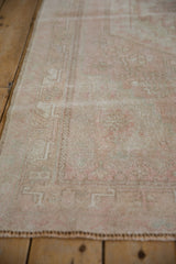 Distressed vintage Oushak rug edge with soft worn pile and geometric border.