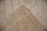Distressed blush and ivory Oushak pile, showing hand-knotted backing and intact selvage.