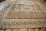 Geometric floral gul border on a distressed hand-knotted vintage Kars carpet.