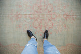 Distressed Oushak carpet with worn texture and faded powder blue, pink pattern.