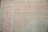 Distressed Oushak corner, showing pink and ivory border patterns with intact selvages.
