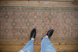 Distressed vintage Hamadan runner with rose pink field, green Herati design, and vine border.