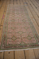 Vintage Hamadan runner's distressed pink field, green Herati florals, and vine border.