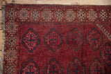 Beshir rug upper left corner, featuring geometric ram's horn border and tattered fringe.