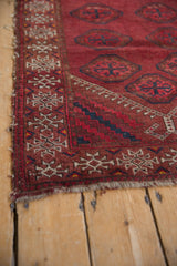 Vintage Beshir rug corner with black cherry red border, ivory ram's horn, tattered fringe.