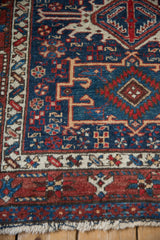 A vintage Karaja rug corner featuring a starburst main border and low, textured pile.