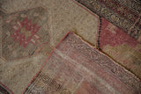 Vintage distressed Hamadan rug corner, revealing worn pile, dusty raspberry, charcoal, and ivory shades.