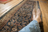 A perspective view down a vintage Hamadan runner, detailing the allover Herati pattern.