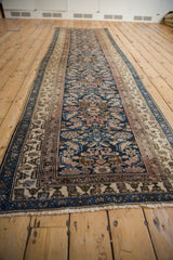 Angled perspective along the length of a vintage Hamadan runner with detailed borders.