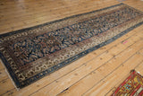 Angled full-length view of a vintage Hamadan runner showing its navy Herati pattern and ivory borders.