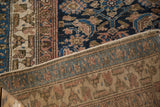Close view of a vintage Hamadan rug's folded corner showing the face and reverse weave.
