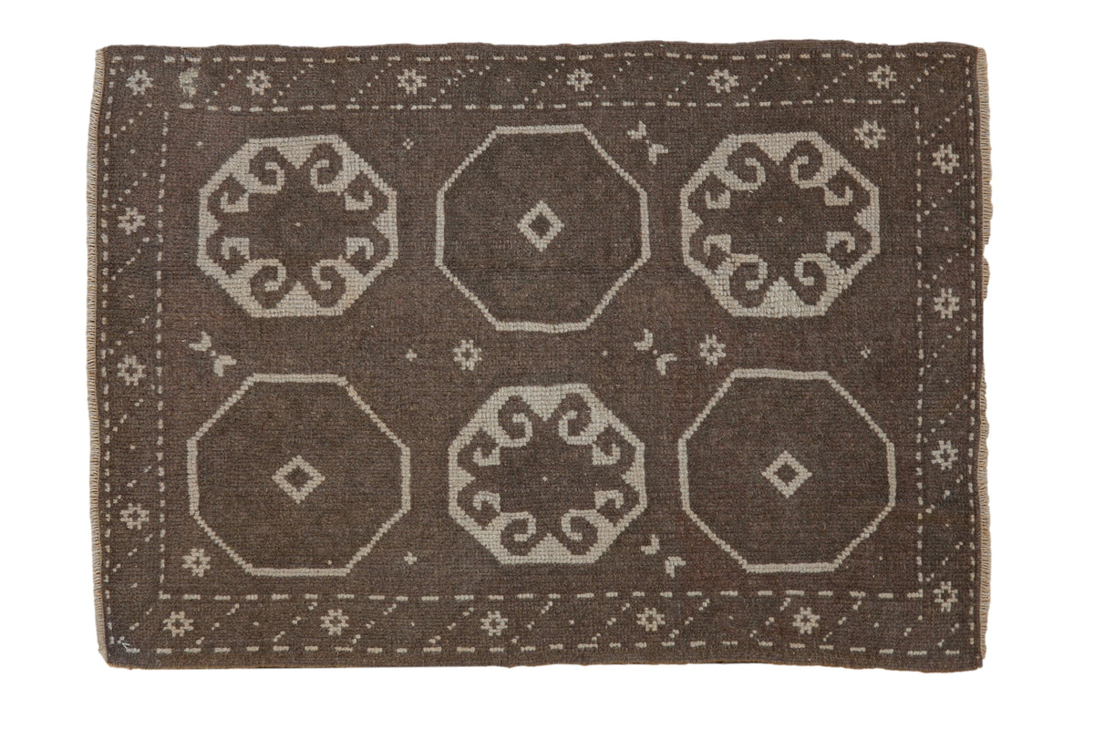 Vintage distressed Oushak rug with octagonal gul medallions in chocolate brown and ivory.