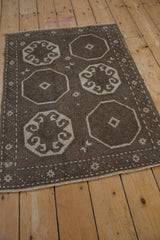 Angled view of the vintage Oushak's octagonal medallions and geometric starburst border.