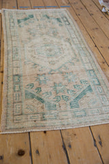 Distressed cream and dusty emerald geometric pattern on vintage Oushak rug pile.