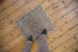 Distressed texture, pale field, and wavy dark border on the Oushak rug corner.