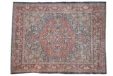 Distressed vintage Sparta carpet with faded madder red, slate, and ivory medallion patterns.