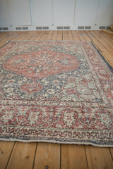 Distressed Sparta carpet with faded madder red medallion, pale slate, and ivory floral patterns.