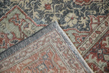 Vintage Distressed Sparta rug corner showing faded red, green pattern and woven foundation.
