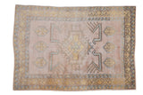 Hand-knotted vintage Distressed Melas rug, geometric medallion in soft mauve, gold, and blue.