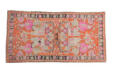 Distressed vintage Oushak rug with hot pink floral bouquets on a tangerine orange field, measuring 3x5.5.