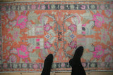 Vintage distressed Oushak rug with hot pink florals on a tangerine field, shown full-length for scale.