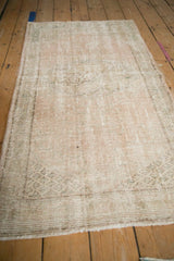 Vintage distressed Oushak rug close-up: worn pile, visible foundation, and pale ivory tones.