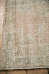 Distressed cream and ivory Oushak runner pile with exposed foundation and intact side cord.