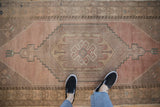 Distressed vintage Oushak rug runner with stepped medallion and faded dusty rose texture.