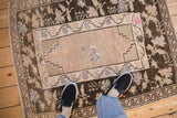 The scale and texture of a vintage distressed Oushak rug as seen from a personal viewpoint.