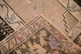 Close-up on the folded corner of a vintage Oushak rug showing the low pile and hand-knotted reverse.