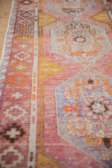 Distressed Oushak runner detail with faded saffron, pale purple, and tangerine hues.