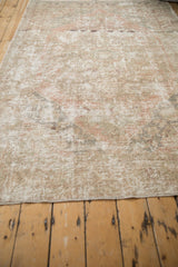 Distressed Oushak rug with faded beige tones, low pile texture, and intact selvage.