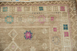 Worn texture and geometric fuchsia and turquoise motifs on this distressed vintage Oushak rug.