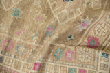 Distressed Oushak rug detail: beige pile texture with faded fuchsia, turquoise starburst florals.