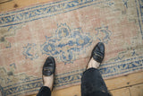 Distressed vintage Oushak runner with visible pile wear and faded dusty rose, sky blue tones.