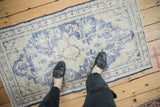 Distressed vintage Oushak rug, with worn cobalt blue patterns and visible foundation.