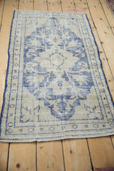 Distressed vintage Oushak rug, faded cobalt blue medallion on ivory, heavy foundation wear, 2'4