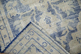 Distressed pile with cobalt blue pattern and rug foundation detail at corner.