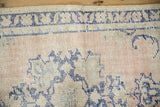 Distressed hand-knotted pile of a vintage Oushak rug with visible knot heads in dusty rose and cobalt blue.