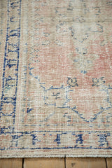 Detail of worn knot heads and foundation on a distressed rug with blush and cobalt blue.