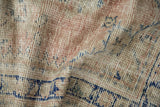 Textural detail of a distressed vintage Oushak rug showing worn blush pile over an ivory foundation.