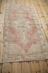 Full length angled view of a distressed Oushak runner with a raspberry rose and sand palette.