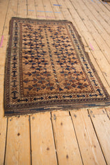 Antique Belouch rug with central barber pole column and sharp serrated leaf motifs.